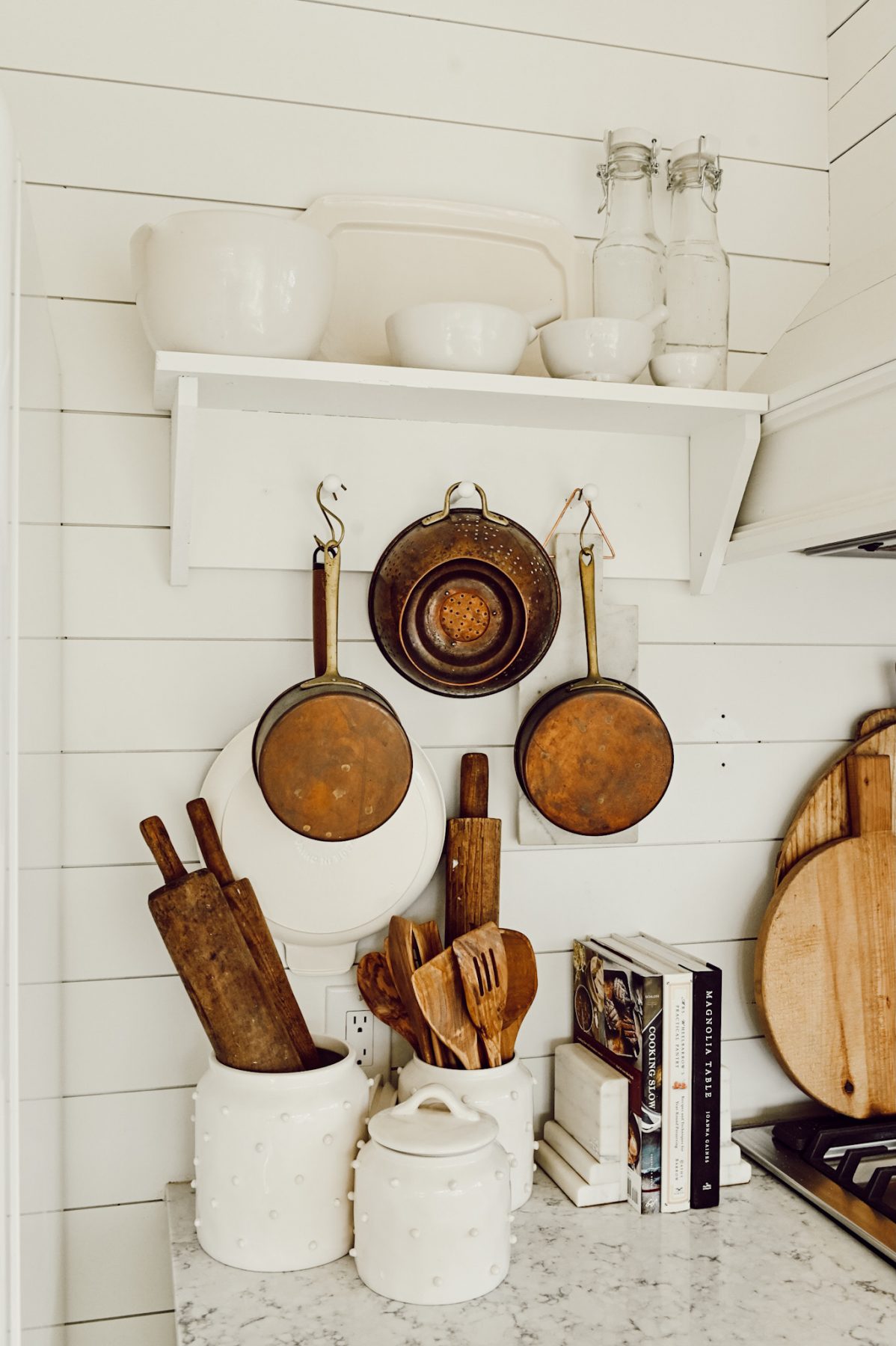 Copper pots and kitchen tools on a white shiplap wall